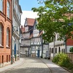Gepflasterte Gasse mit historischen Fachwerkhäusern und roten Dächern im Zentrum von Wolfenbüttel.