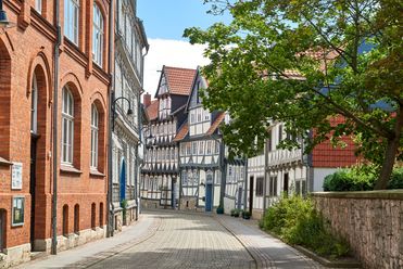 Gepflasterte Gasse mit historischen Fachwerkhäusern und roten Dächern im Zentrum von Wolfenbüttel.