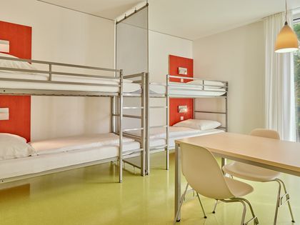 Zwei Doppelstoclbetten und ein Tisch für vier Personen