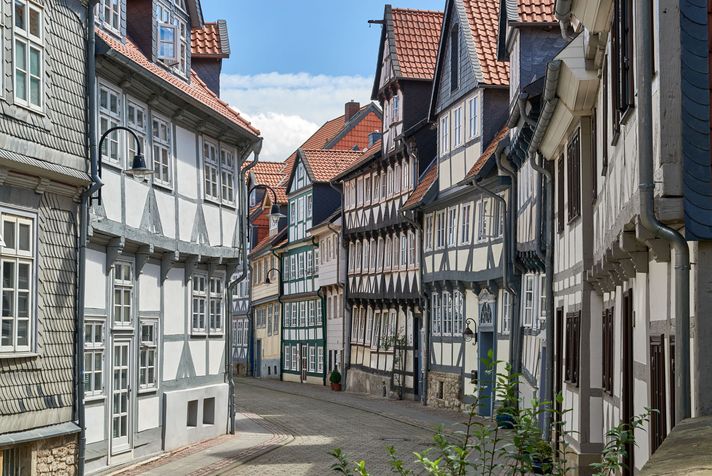 Enge Gasse mit historischen Fachwerkhäusern und roten Ziegeldächern in der Altstadt von Wolfenbüttel.
